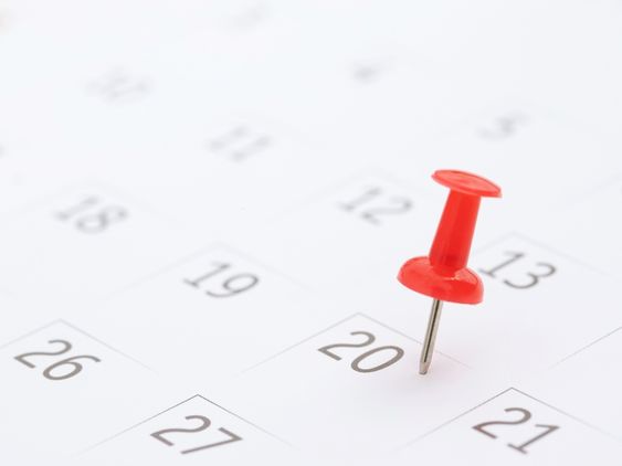 Photo of white calendar with red push pin